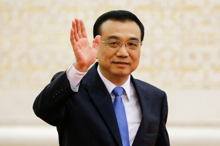 FILE PHOTO: China's Premier Li Keqiang waves as he arrives for a news conference after the closing ceremony of China's National People's Congress (NPC) at the Great Hall of the People in Beijing